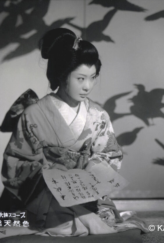 Daibosatsu pass. Svart-hvitt bilde fra japansk film (1960): En kvinne i kimono holder et brev, en mann i tradisjonell drakt sitter ved siden av henne.