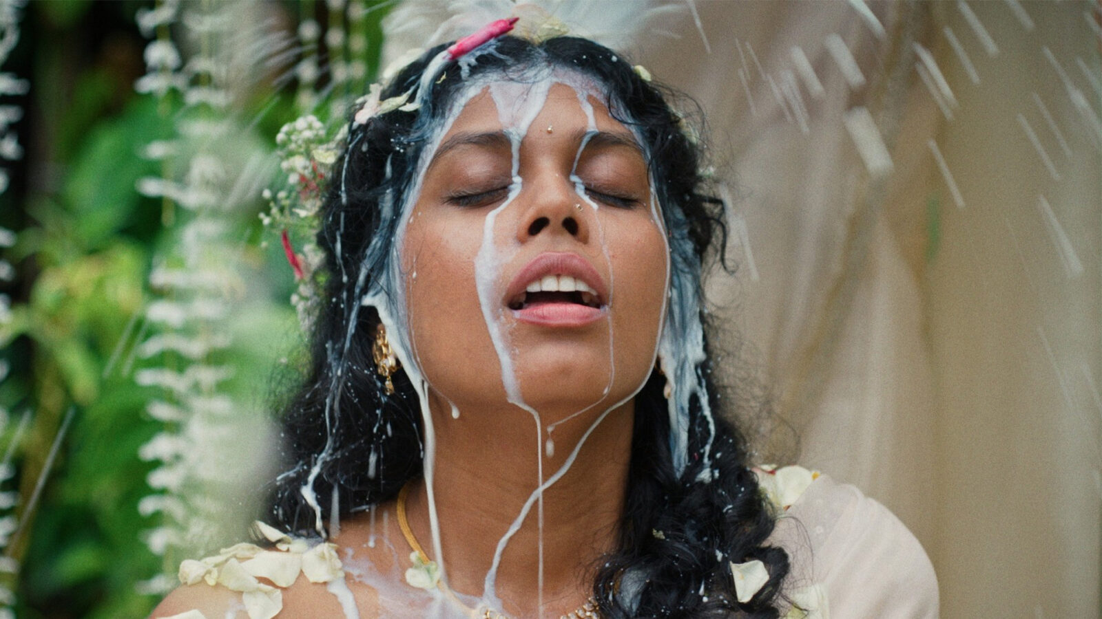 The Difficult Bride En kvinne med blomster i haaret og gullsmykker faer helt en hvit vaeske over hodet Hun har oeynene lukket og munnen aapen