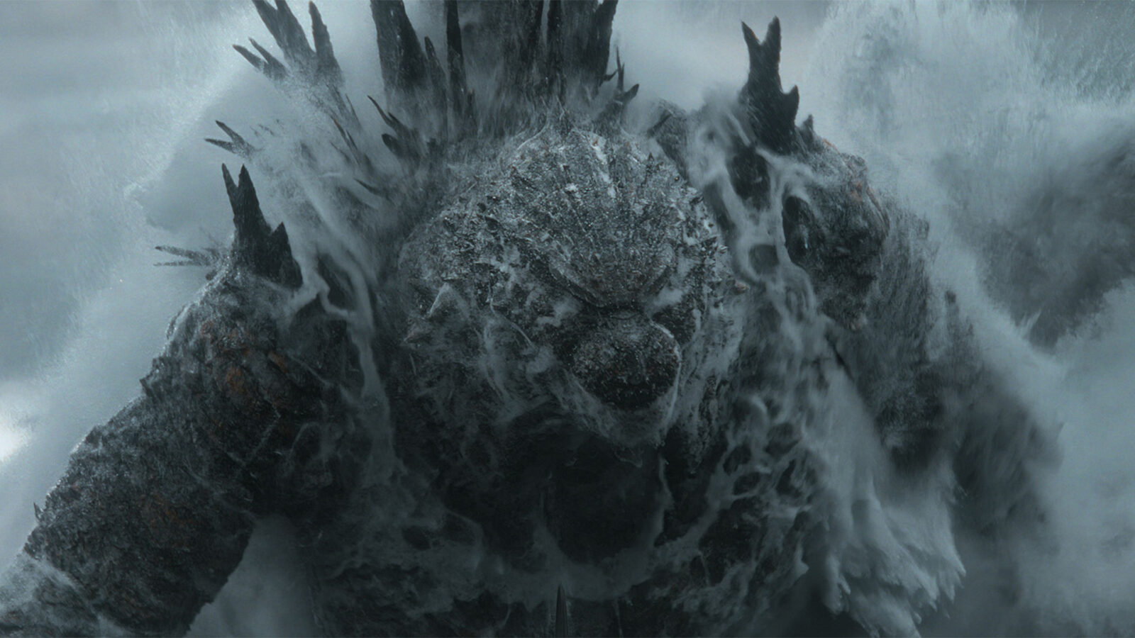 Godzilla Minus Zero Et stort monster med taggete rygg som reiser seg fra havet omgitt av vannsprut