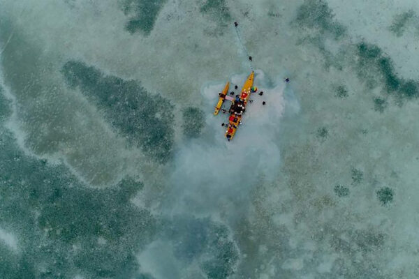Oceania Regissørsamtale. Bildet viser en gruppe mennesker i en tradisjonell kano på grunt vann, trolig knyttet til utforskning eller kultur i Oseania.